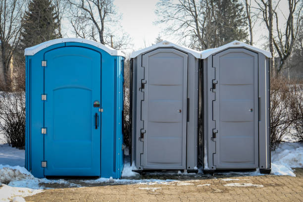 portable toilets in a snowy outdoor setting during winter.